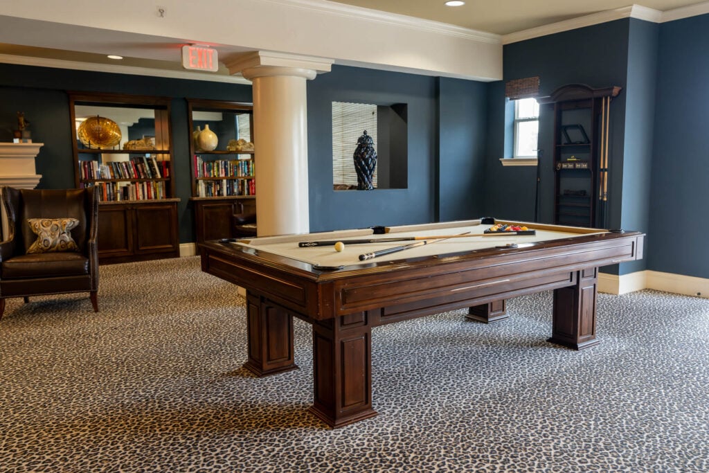 Billiards Room With Bookshelves at Independent Living Facility