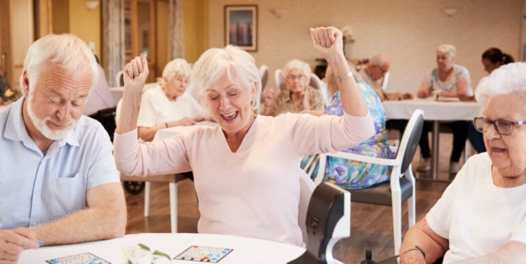 Elderly Woman Celebrating Bingo Win at Independent Living Facility